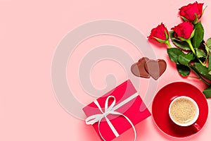 Romantic Valentine's day flat lay with copy space for text. Red roses, gift bos, chocolate hearts and cup of coffee on