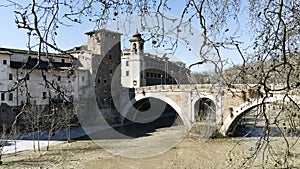 Romantic view of ancient Roman Fabricio bridge well preserved and pedestrian way to go to Tiberina Island on Tiber river in