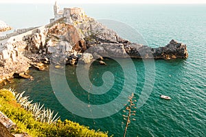 Romantic view of Porto Venere`s famous Byron Bay with st. peter`s church at sunset with warm light and calm blue see during