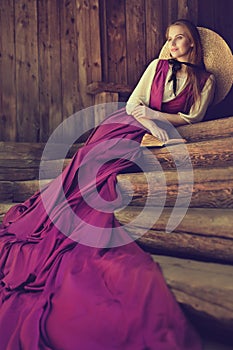 Romantic Vintage Woman Fashion. Victorian Lady relax Outside on wooden Steps. 19th Century Female Historical Dress Costume