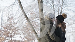 Romantic walk of a couple on a snow park in wonderful winter weather