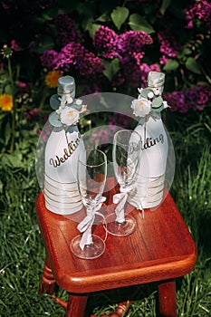 Romantic wedding arrangement of two bottles of champagne and glasses on a stool