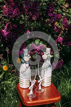 Romantic wedding arrangement of two bottles of champagne and glasses on a stool