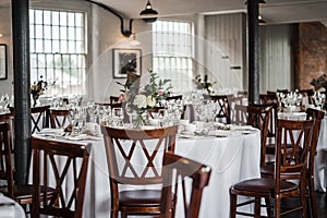 Romantic wedding breakfast room set up for guests and the bride and groom