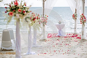 Romantic wedding ceremony on the beach. Wedding setting on the beach. Flowers wedding ceremony by the sea.
