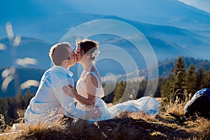 Romantic wedding couple kissing on the top of mountain