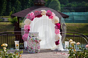 Romantic white wedding aisle archway with rose petals, flowers a