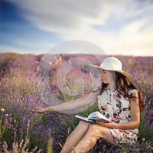 Romantic woman with book on lavender field