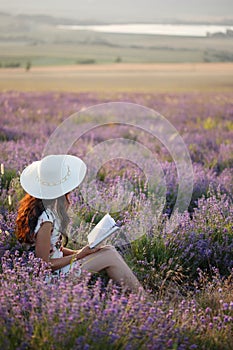 Romantic woman with book on lavender field