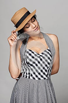 Romantic woman in chequered summer dress dreaming with closed eyes