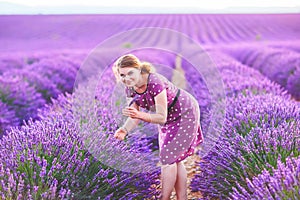 Romantic woman in lavender fields, having vacations in Provence, France. Girl traveling through Valensole plateau