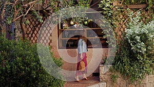 Romantic woman in red dress looking to showcase or shop window of old traditional bakery shop in old town Antibes