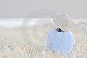 Romantic woman sitting in tall long grass