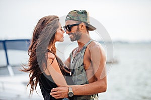 Romantic young beautiful couple in love embracing at the pier