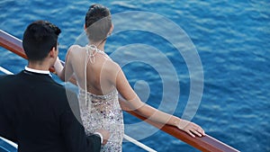 Romantic young couple enjoying ocean view from open deck on cruise ship boat. Happy lovers or bride and groom dressed