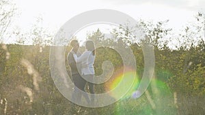 Romantic young couple hug and spin around on nature. Slowly