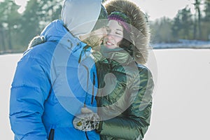 Romantic young couple hugging outdoor in winter frosty day