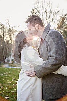 Romantic young couple kissing outside on a cold fall day