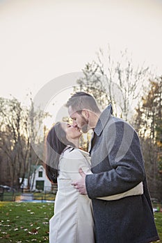 Romantic young couple kissing outside on a cold fall day