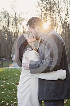 Romantic young couple kissing outside on a cold fall day