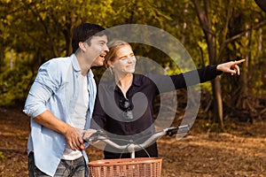 Romantic young couple in love and going for a bike ride on a sunny day in the park