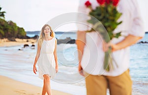 Romantic Young Couple in Love, Man holding surprise bouquet of r