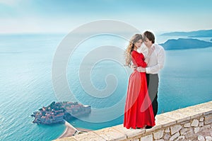 Romantic young couple in love over sea shore background. Fashion