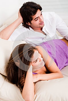 Romantic young couple lying in couch