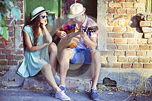 Romantic young couple playing Guitar outdoor