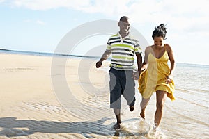 Romantic Young Couple Running Along Shoreline photo