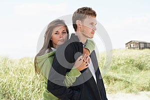 Romantic Young Couple Standing By Dunes photo