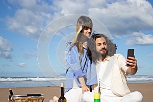 Romantic young couple taking selfie at the beach