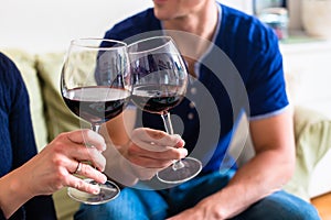 Romantic young couple toasting with red wine while sitting on th