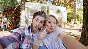 Romantic young couple. travel trailer background, taking selfie in nature, chatting, fooling around, having fun