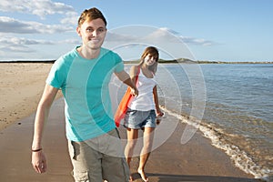 Romantic Young Couple Walking Along Shoreline