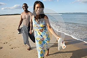 Romantic Young Couple Walking Along Shoreline