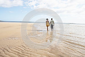 Romantic Young Couple Walking Along Shoreline