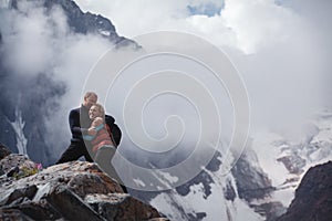 Romantic young happy couple kissing and hugging. rain and fog. Young couple in love on the background of mountains