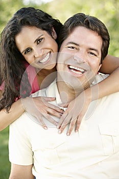 Romantic Young Hispanic Couple Relaxing In Park