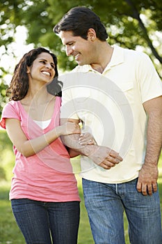 Romantic Young Hispanic Couple Walking In Park