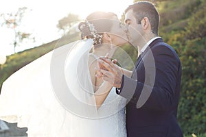 Romantic Young Newlywed Kissing at Garden