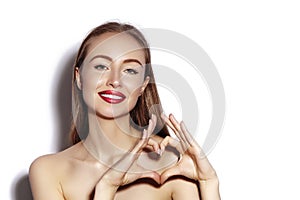 Romantic young Woman making Heart Shape with her Fingers. Love and Valentines Day Symbol. Fashion girl with Happy Smile