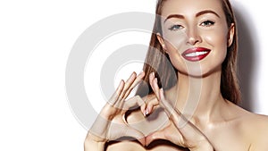 Romantic young Woman making Heart Shape with her Fingers. Love and Valentines Day Symbol. Fashion girl with Happy Smile