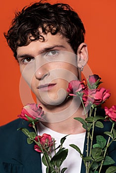 romantical young man posing near roses