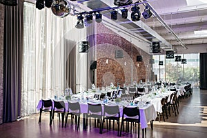 Romantically decorated wedding hall with reflectors, and a set table for the wedding celebration,