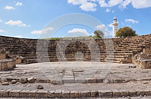 Rome ampitheatre for some occasion in Paphos. Ancient theater with white lighthouse in background, in Pafos, Cyprus.