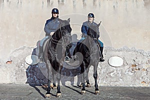 Mounted police officers patrolling street on black horses in Rome