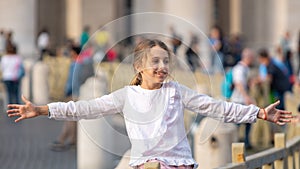 Rome, Italy - 29.10.2019: happy beautiful girl with outstretched arms in the Vatican Square