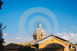 Rome, Italy - An horizontal shot of the Basilica Aemilia partially covered by the roof of a yellow house during a clear sky