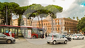 ROME, ITALY - OCTOBER 07, 2018: Red passenger bus and passenger car transport on Rome street in the central part of the